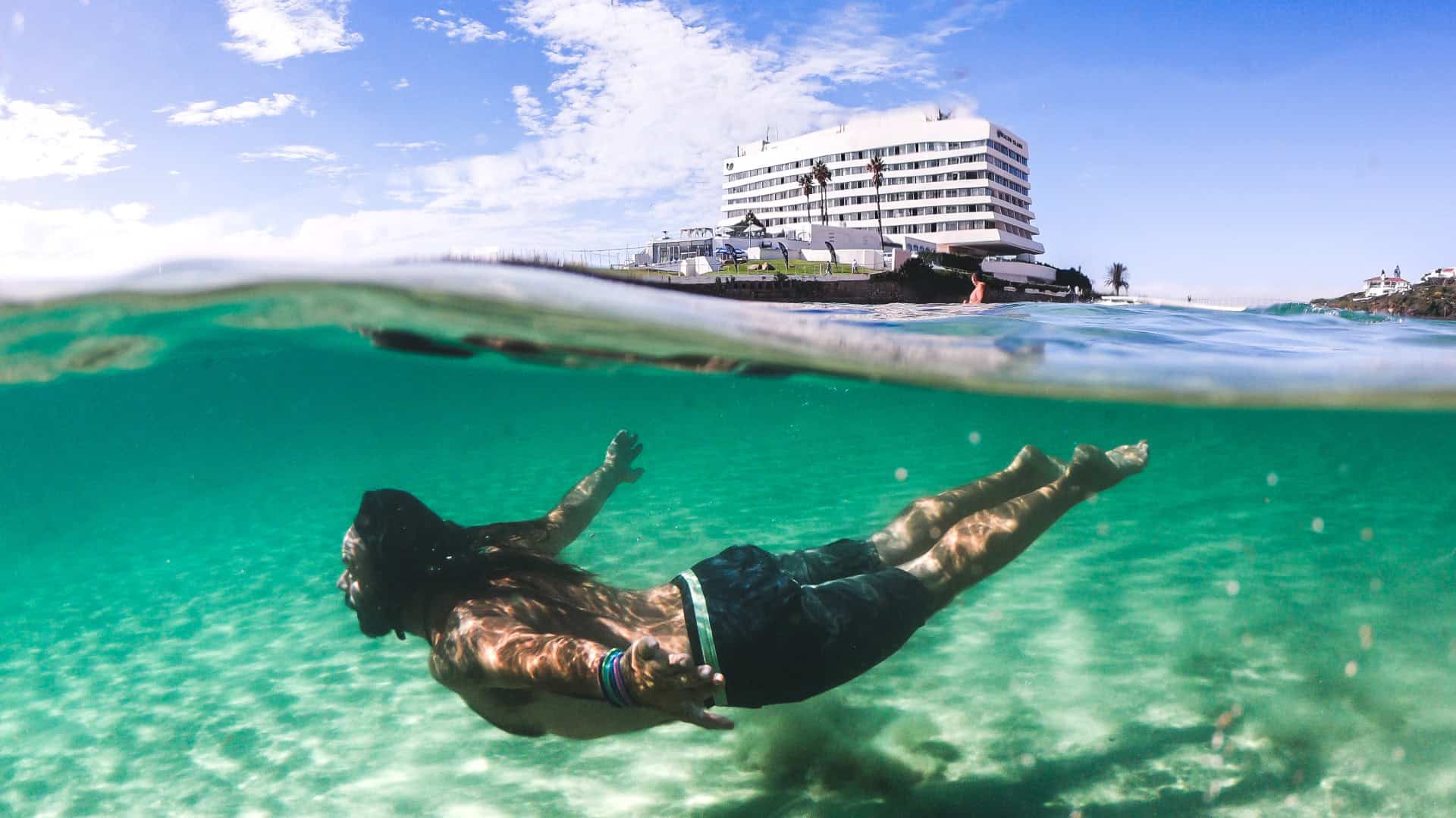 man swimming in the sea at Beacon Isle in Pletternberg Bay