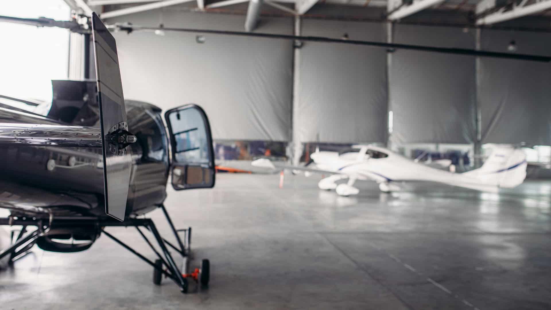 helicopter and planes in a hangar