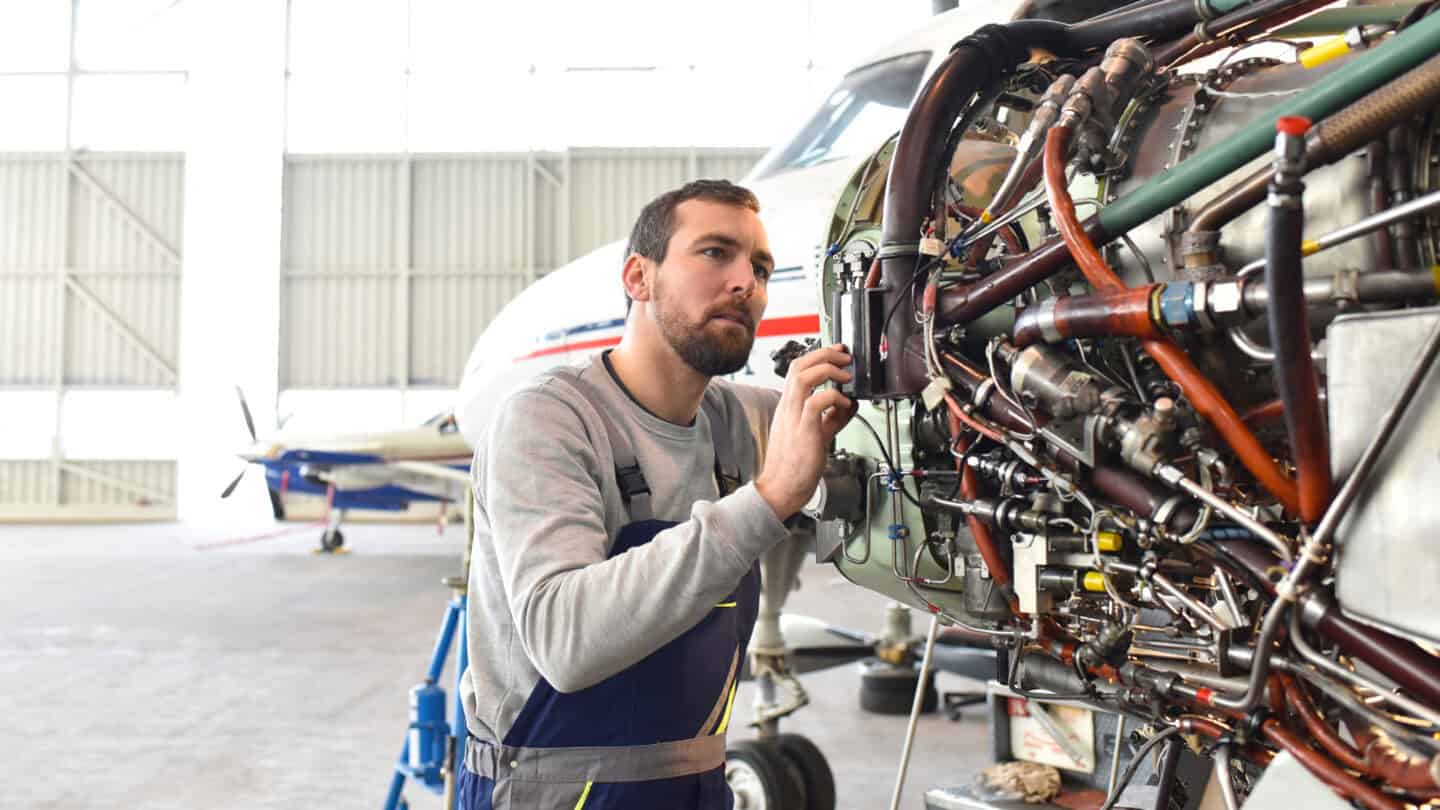aircraft mechanic working on a plane engine