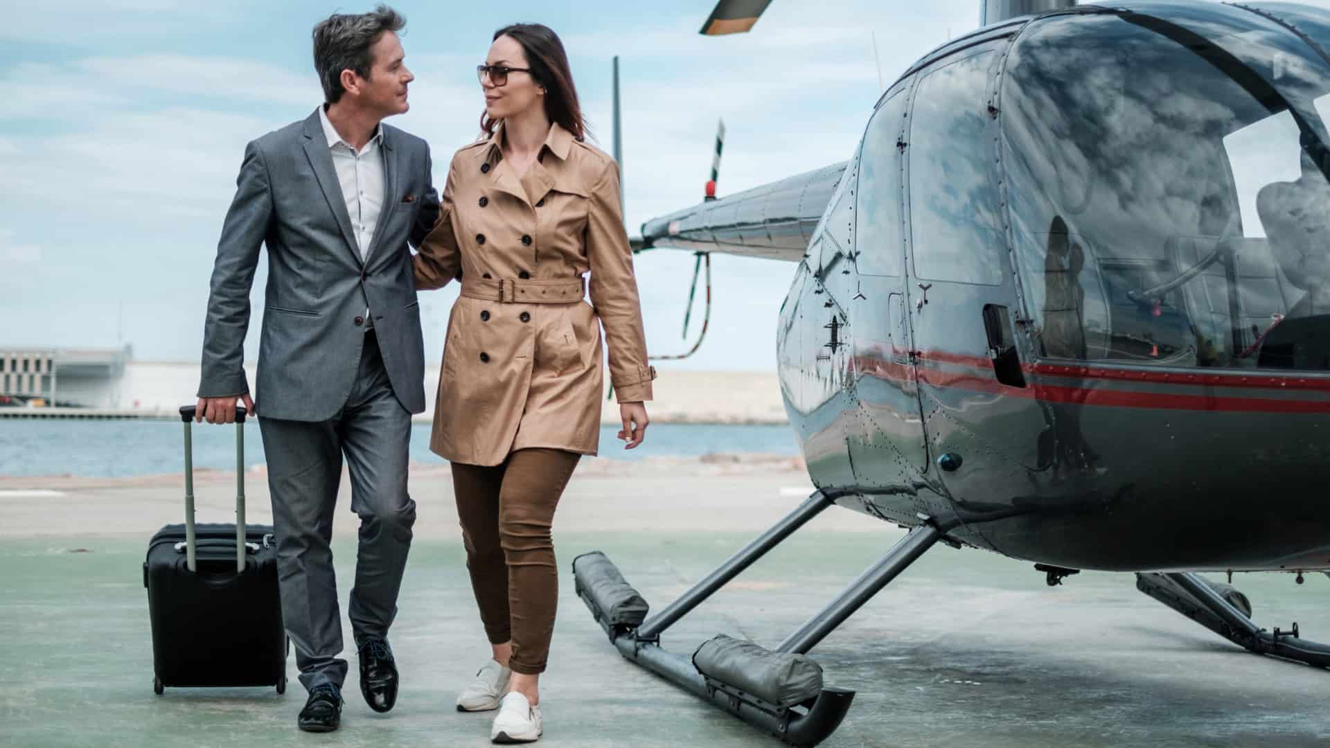 businessman and woman walking from a helicopter to the airport terminal