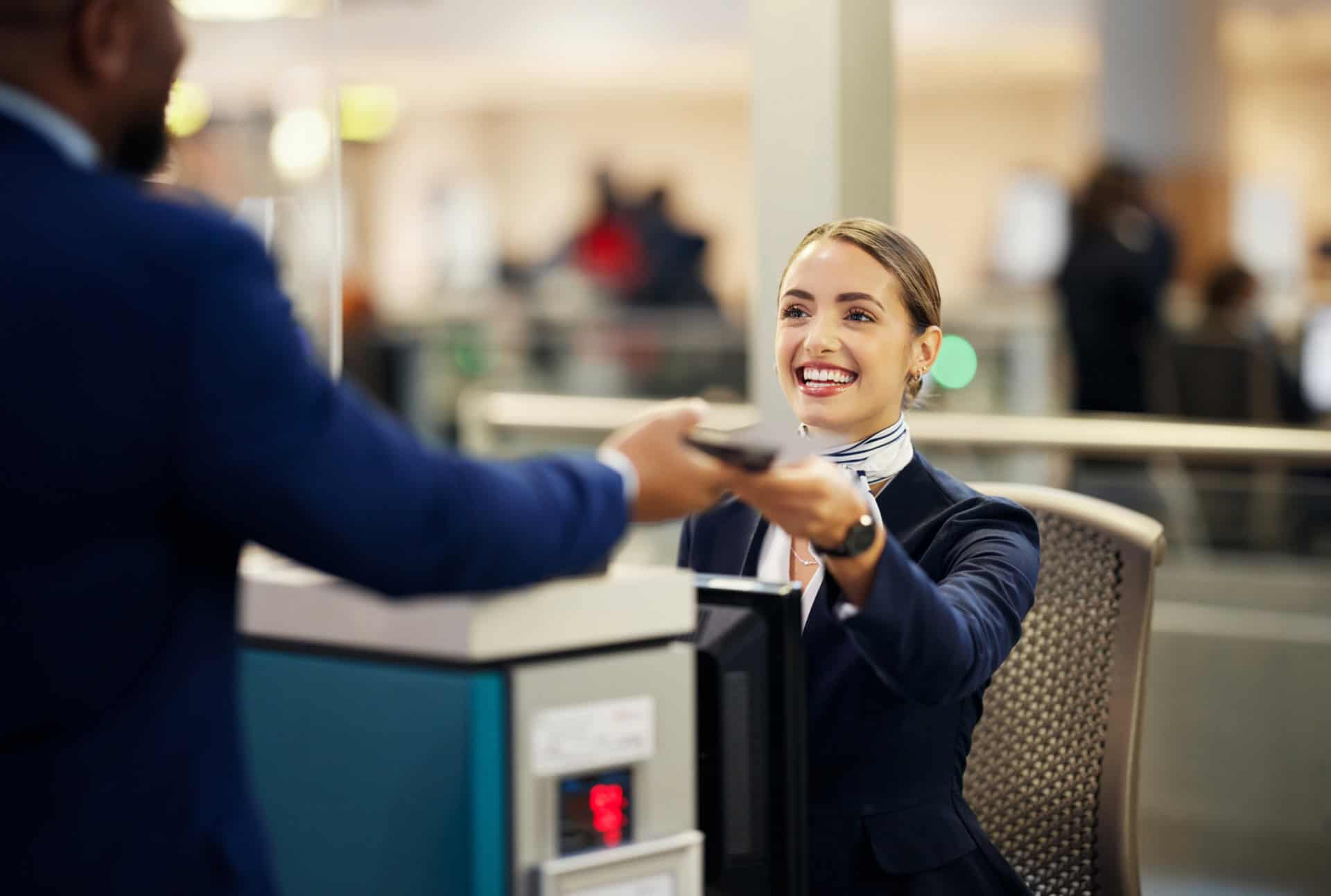 man checking in at the airport being helped by a friendly lady